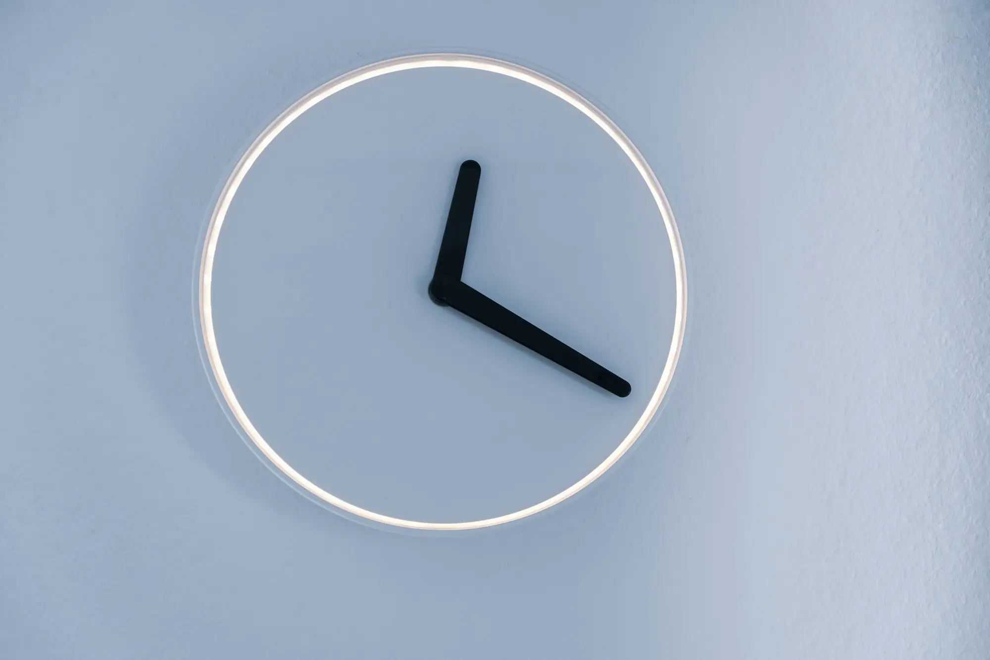 Close view of an analogue clock face showing the time ticking on