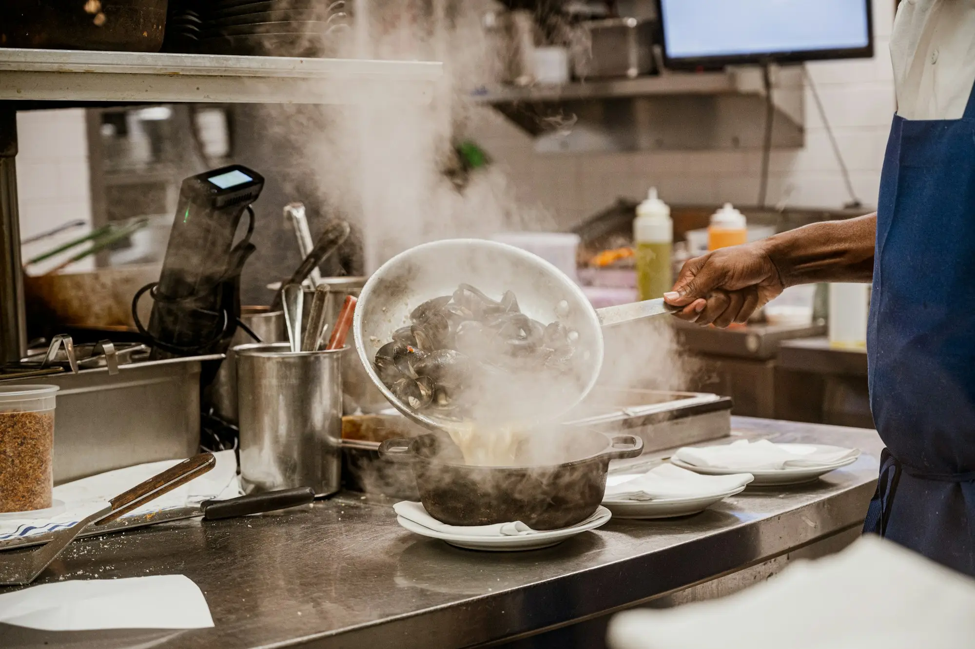 Chef cooking food on a stove in a commercial kitchen