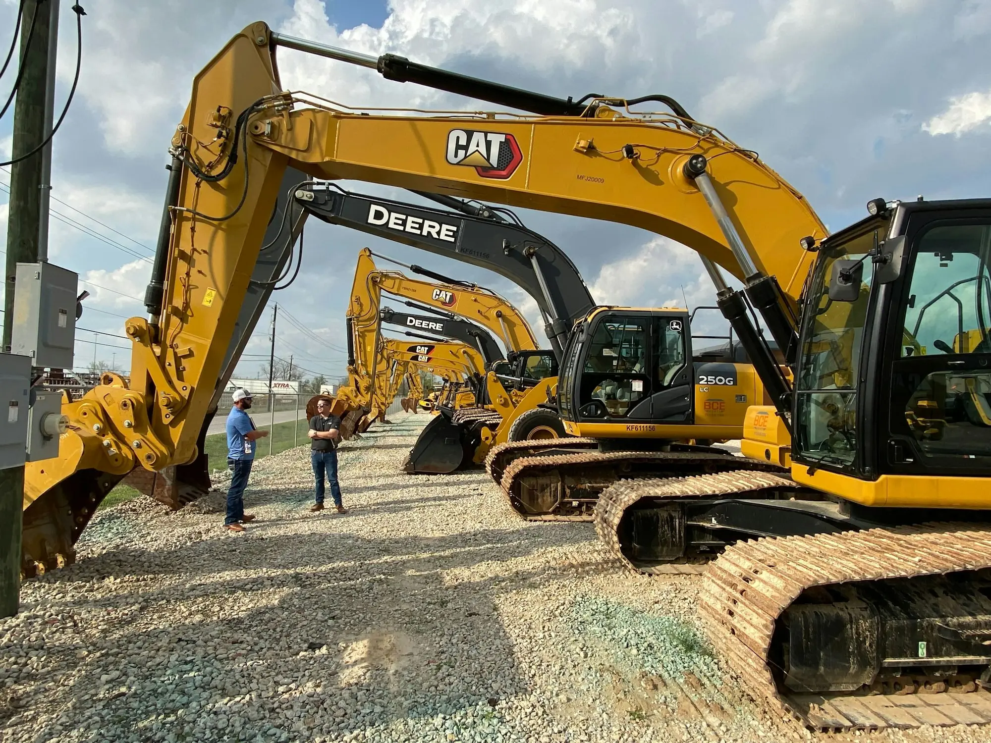 Two men standing beside a yellow bulldozer on a worksite