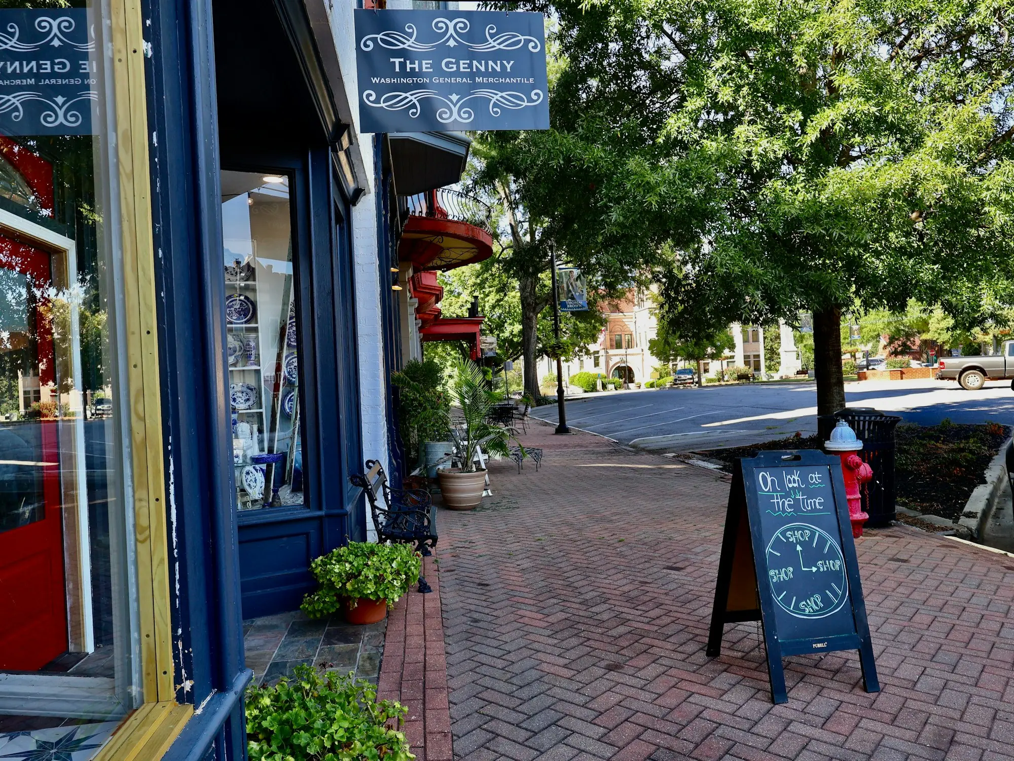 Small shopfront with a chalkboard sign on a brick footpath