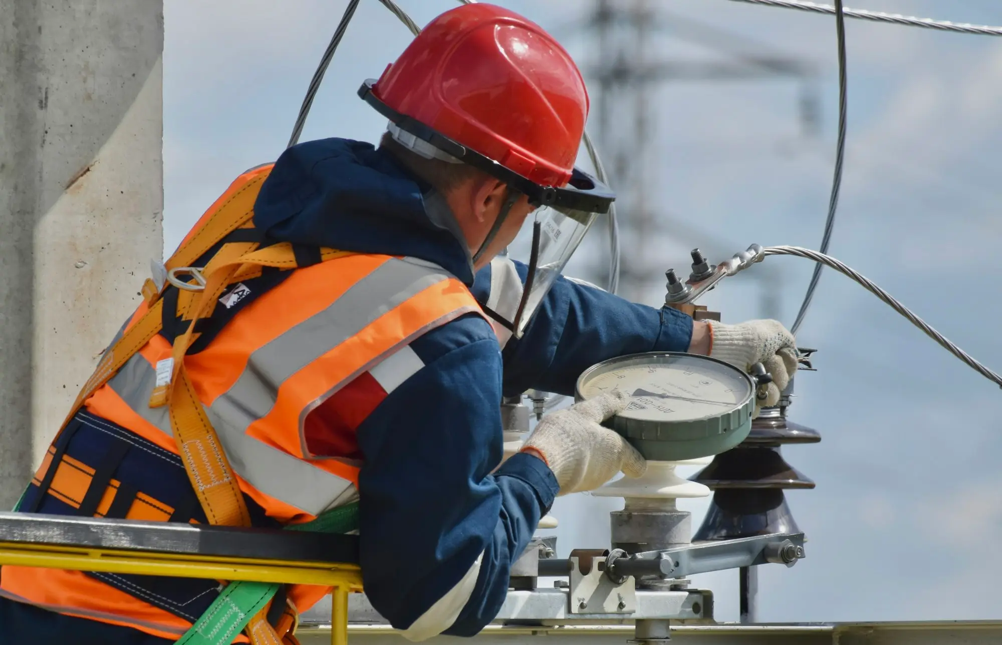 Worker in a high-visibility jacket and red safety helmet on site